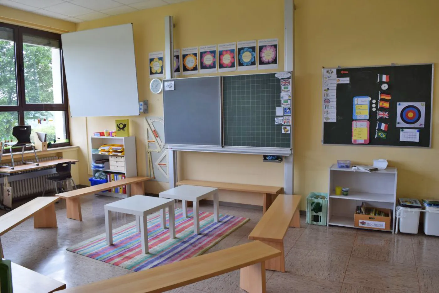 Klassenraum der GGS Auf dem Höchsten mit Tafel, Sitzbänken und buntem Teppich